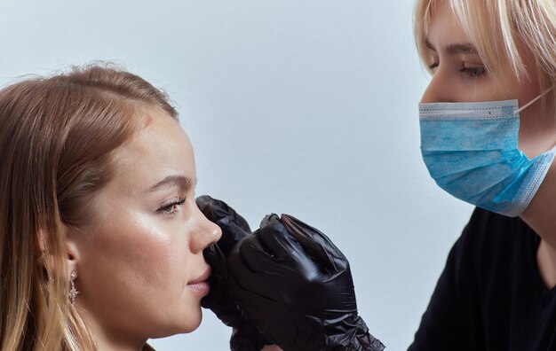 Close-up del viso di una giovane donna con un piercing appeso al naso