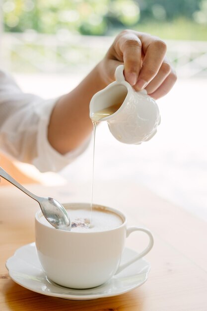 Close-up della mano che prepara il caffè a tavola