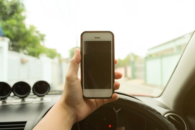 Close-up della mano che usa lo smartphone in auto