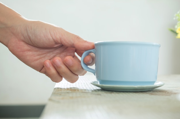 Close up della mano di una tazza di caffè.