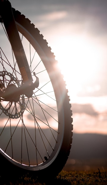 Close-up della ruota di una bicicletta contro il cielo durante il tramonto