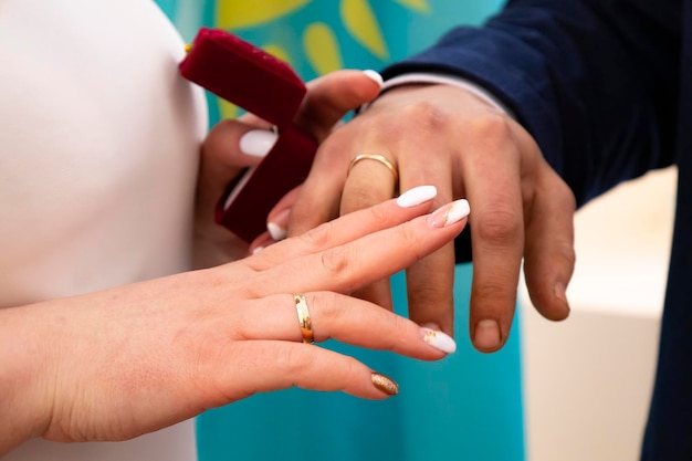 Close-up della sposa e dello sposo che si mettono l'anello sul dito nella cerimonia