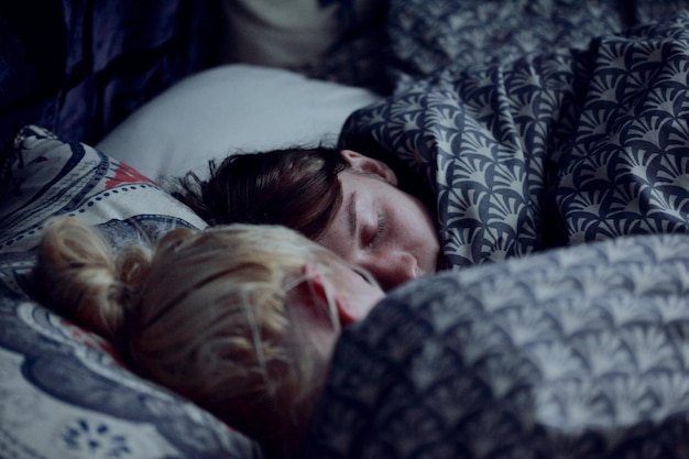 Close-up delle sorelle che dormono sul letto