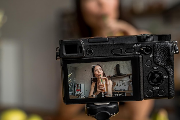 Close-up dello schermo della telecamera che mostra una donna che beve succo fresco al tavolo della cucina