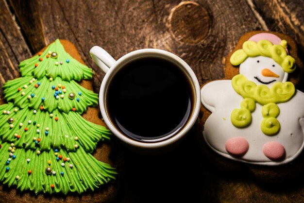 Close-up di caffè nero con biscotti di Natale su un tavolo di legno