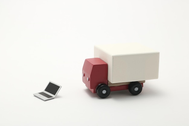 Close-up di camion giocattolo e portatile su sfondo bianco