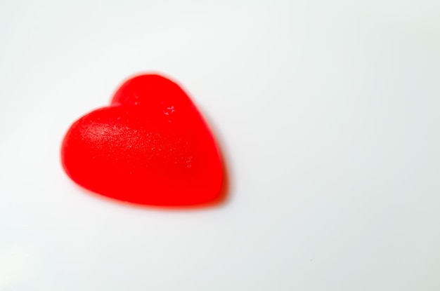 Close-up di caramelle a forma di cuore rosso su sfondo nero