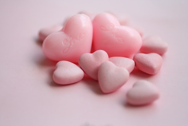 Close-up di caramelle a forma di cuore su sfondo rosa