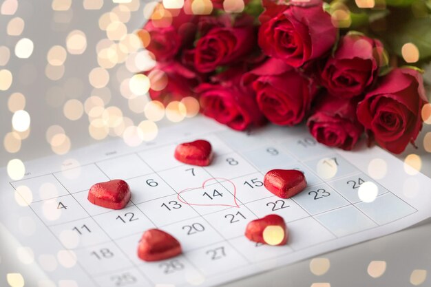 close up di caramelle di cuore di calendario e rose rosse