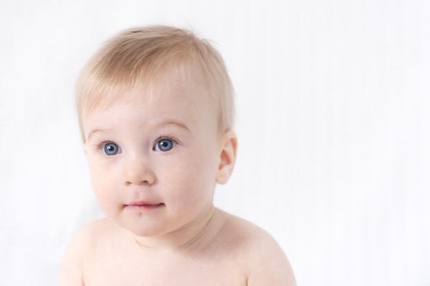 Close-up di carino piccolo adorabile divertente caucasica topless bambina o ragazzo su bianco, sfondo grigio chiaro.pelle sana. concetto di infanzia felice, copia spazio per il testo