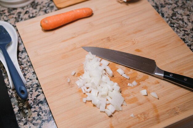 Close-up di cipolla tagliata con un coltello sul tavolo della cucina Cucinare cibo sano