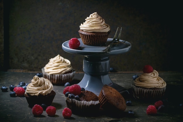 Close-up di cupcake al cioccolato con panna montata con bacche su tavola