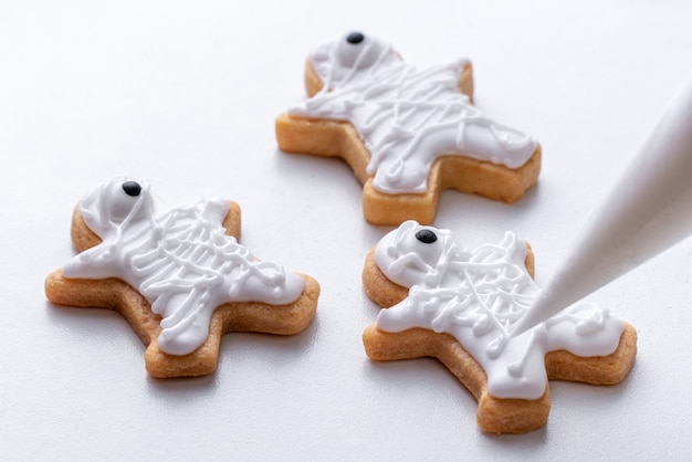 Close up di decorare graziosi biscotti di panpepato di Halloween con glassa glassa crema topping bag.