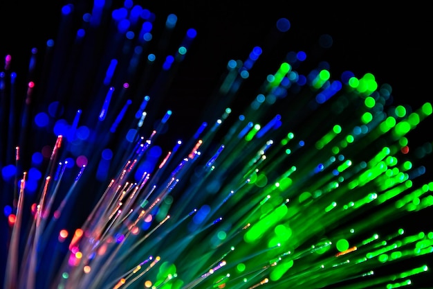 Close-up di fibre ottiche illuminate su uno sfondo nero