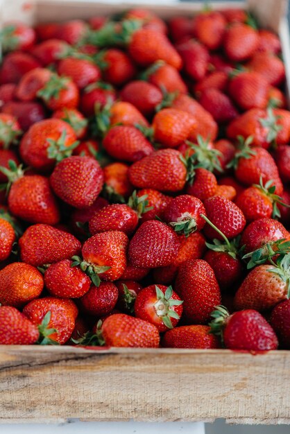 Close-up di fragole fresche mature in un contenitore in vendita. Dieta sana.