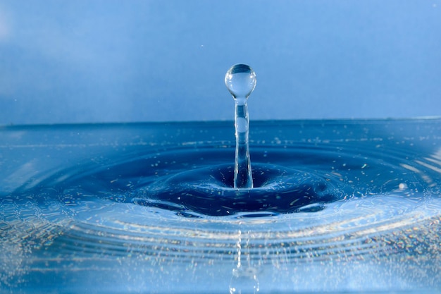 Close-up di gocce che schizzano sull'acqua blu