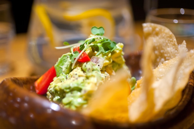 Close-up di insalata di avocado e gamberetti freschi con patatine fritte