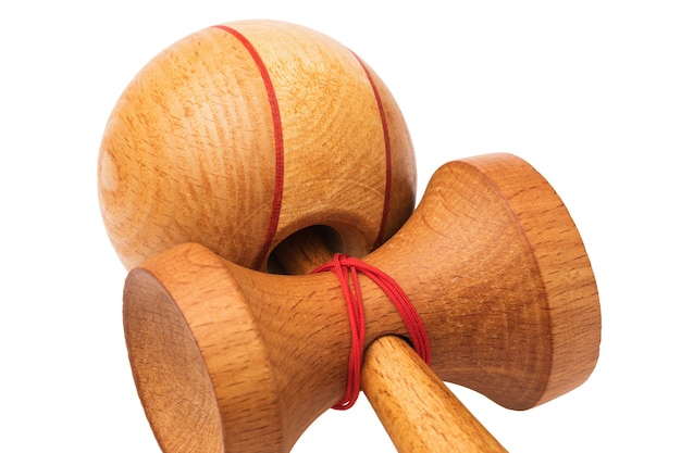 Close-up di kendama giocattolo in legno con fili rossi isolati su sfondo bianco