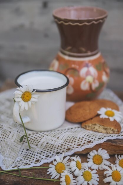Close-up di latte in tazza con fiori bianchi sul tavolo