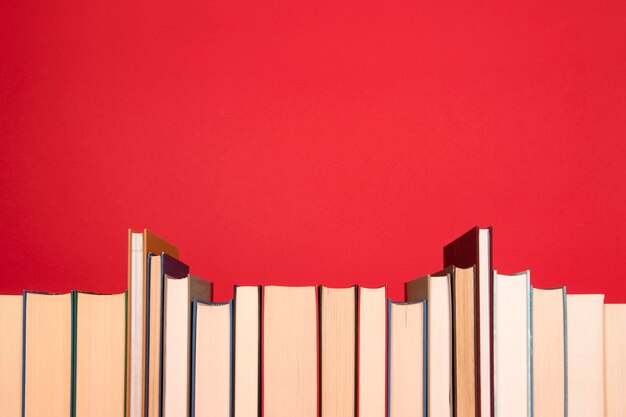 Close-up di libri disposti su uno sfondo rosso