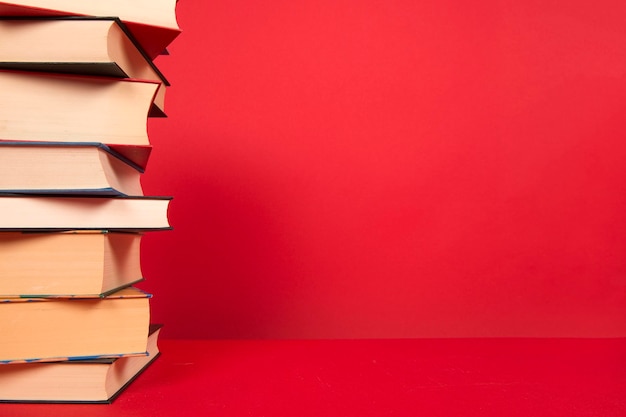 Close-up di libri impilati su uno sfondo rosso