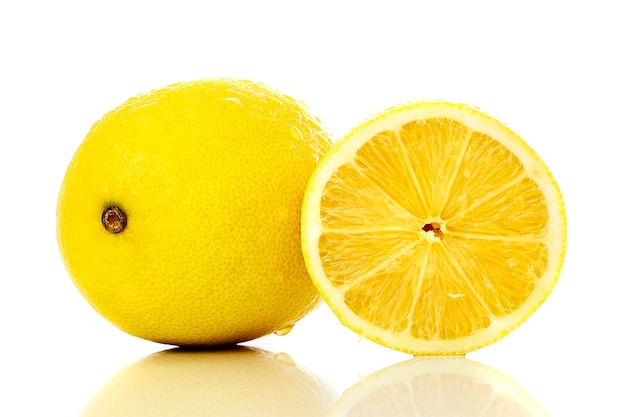 Close-up di limoni gialli freschi e bevanda su sfondo bianco
