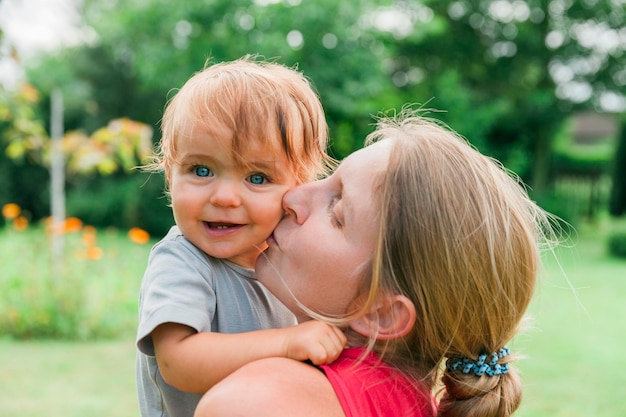 Close-up di madre che bacia la figlia nel parco