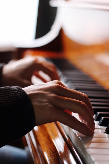 Close-up di mani che suonano il pianoforte a casa