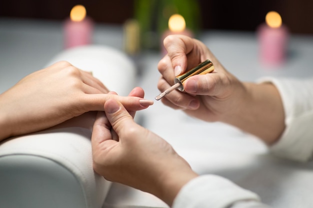 Close-up di mani femminili durante la routine di manicure in uno studio di maniglia