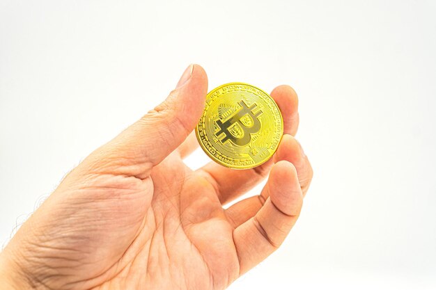 Close up di mano che tiene bitcoin criptovaluta futuro business Mano che tiene bitcoin d'oro su sfondo bianco Nuove tecnologie e criptovalute nonché investimenti nel mining e halving.
