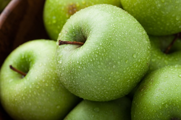 Close-up di mele verdi mature ricoperte di rugiada.
