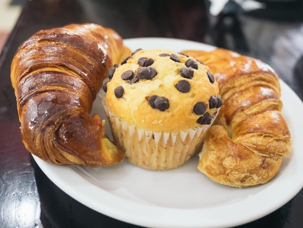 Close-up di muffin e croissant in piatto su tavola