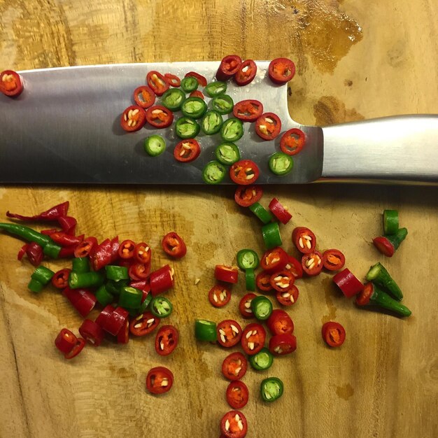 Close-up di peperoncini tagliati con un coltello sul tavolino da taglio