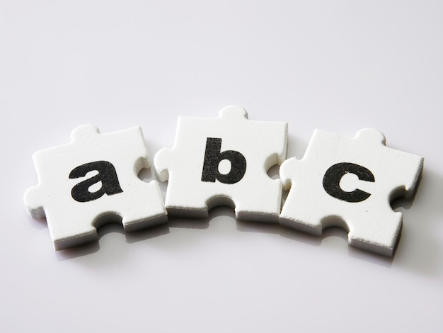 Close-up di pezzi di puzzle con testo su sfondo bianco