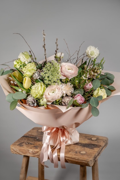 Close-up di piccoli fiori rosa bouquet in vaso di vetro con sfondo grigio sfocato. Matrimonio o compleanno, concetto di San Valentino.