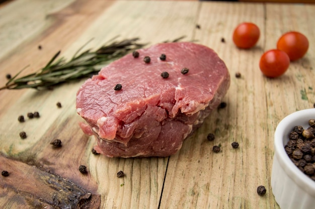Close-up di tonno con rosmarino e peperoncino nero su un tavolo di legno