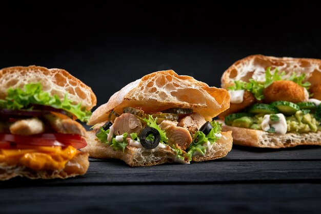 Close-up di tre diversi panini o hamburger appetitosi sullo sfondo di legno