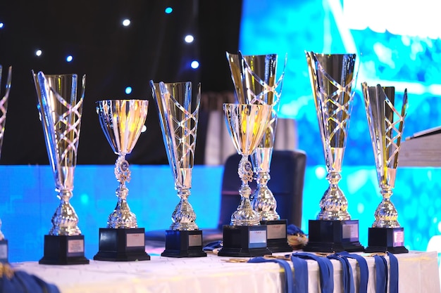 Close-up di trofei d'oro allineati ad un evento di danza Collezione di trofei Coppe di premiazione close-up