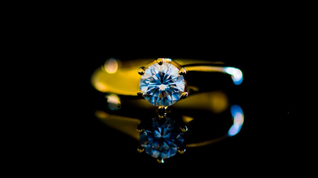 Close-up di un anello di diamanti con riflesso su uno sfondo nero