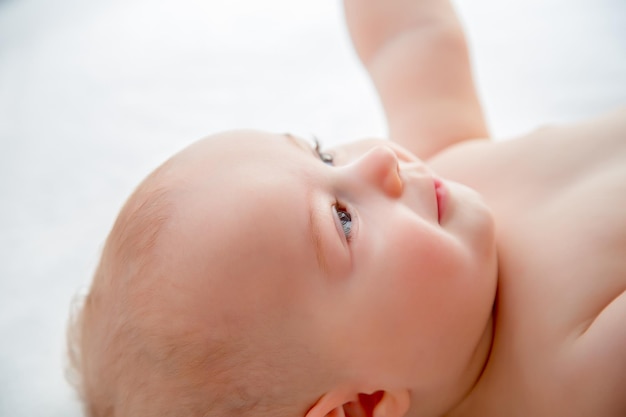 Close-up di un bambino senza maglietta sdraiato sul letto