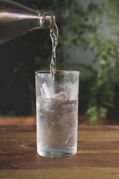 Close-up di un bicchiere che versa acqua sul tavolo