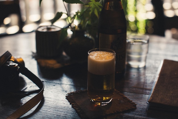 Close-up di un bicchiere di birra con una telecamera sul tavolo