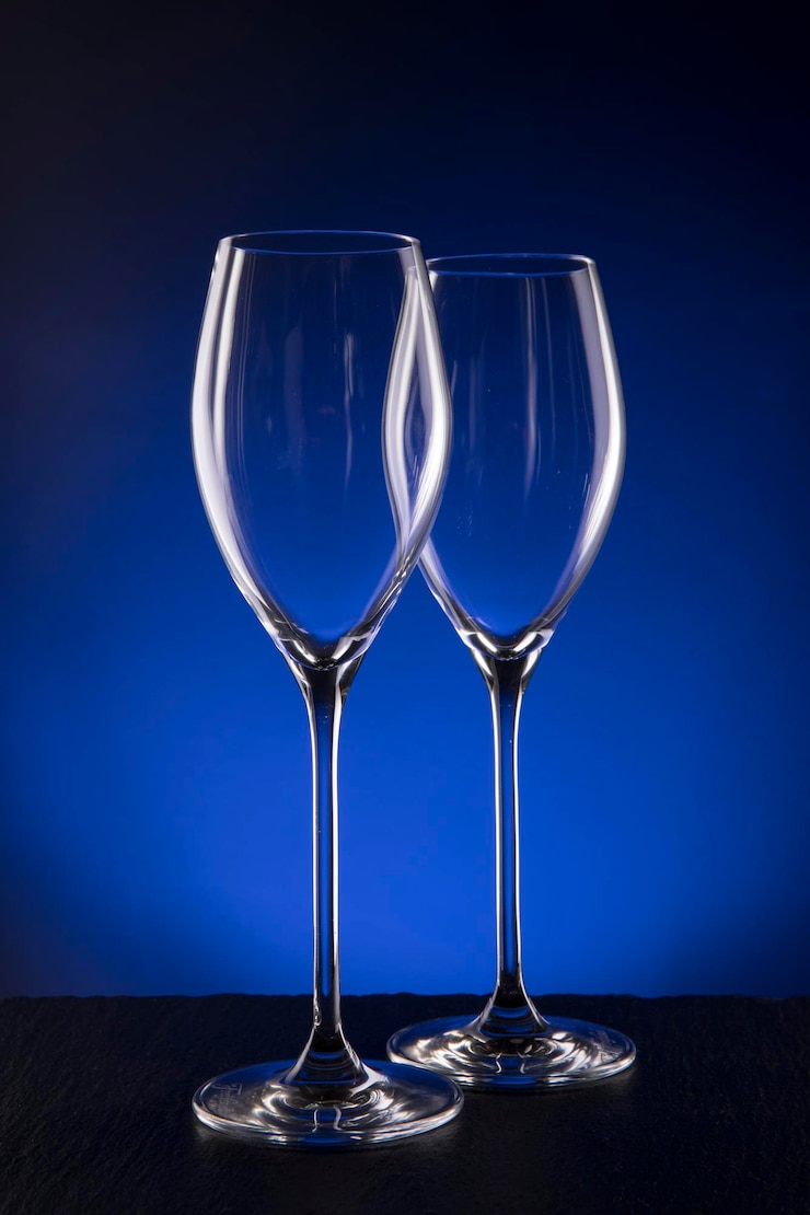 Foto close-up di un bicchiere di vino su tavola su uno sfondo blu