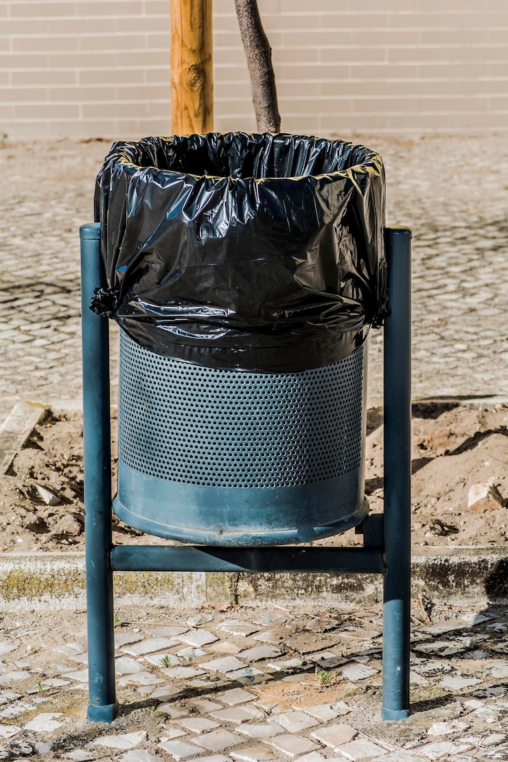 Foto close-up di un bidone della spazzatura sul marciapiede contro il muro