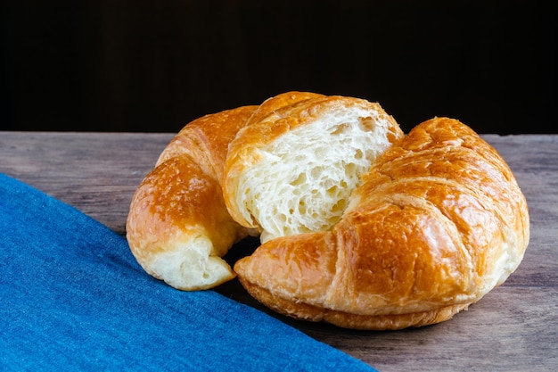 Close-up di un croissant con un tessuto blu sul tavolo