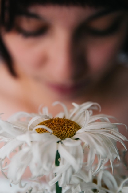 Close-up di un fiore bianco con una donna sullo sfondo