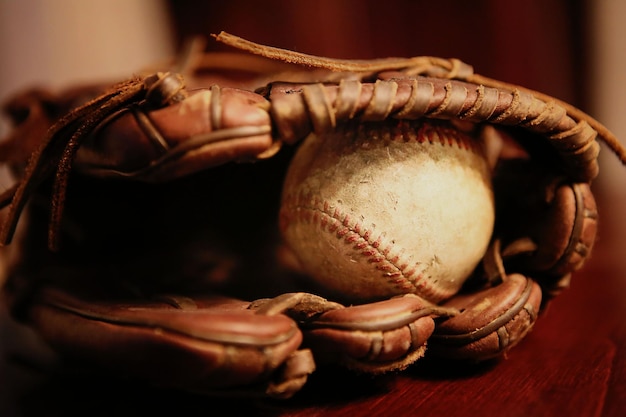 Close-up di un guanto da baseball con la palla sul tavolo