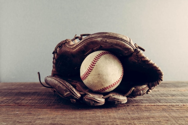 Close-up di un guanto da baseball e una palla sul tavolo
