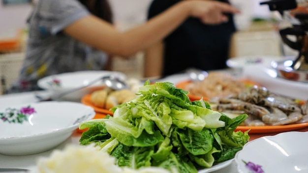 Close-up di un'insalata sul tavolo con le donne sullo sfondo
