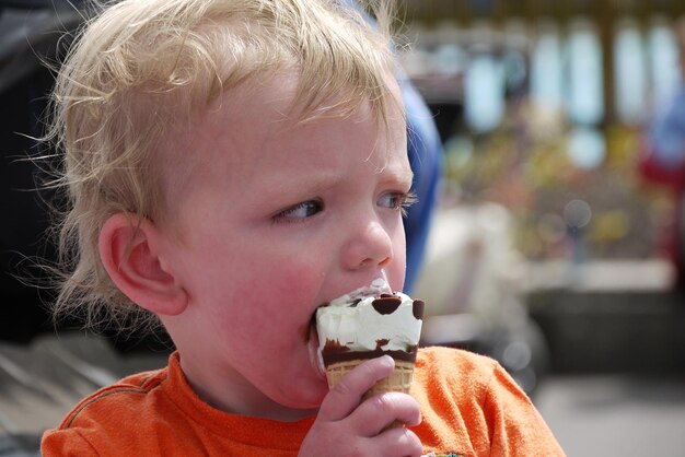 Close-up di un ragazzo che mangia il gelato all'aperto